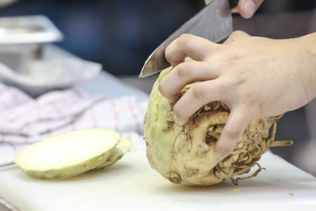 Close up of man cutting vegetable on cutting boardの写真素材