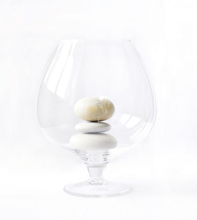 White transparent glass with three pebblesの写真素材