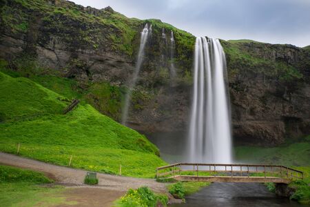 Iceland - Waterfalls of Seljalandsfoss with bridge and river and stairsの写真素材
