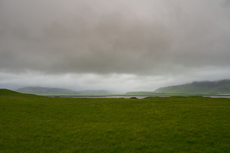Iceland - Rain over green fields and mountains at the south coastの写真素材