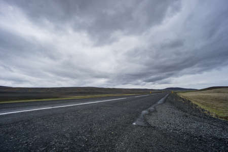 Iceland - Dark road with no end through lava fieldsの写真素材