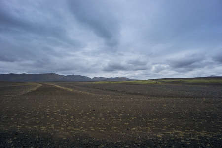 Iceland - Wide scraggy lava landscape and mountain chainの写真素材