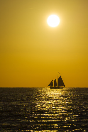 USA, Florida, Beautiful romantic evening mood at key west with sailing ship under orange sunの写真素材