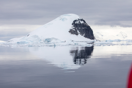 icecaps in the Antarctica with iceberg in the ocean swimming around and melting in the seaの写真素材