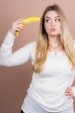 a girl plays with a banana and had funの写真素材