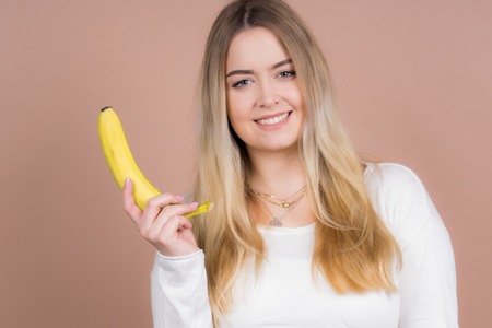 a girl plays with a banana and had funの写真素材