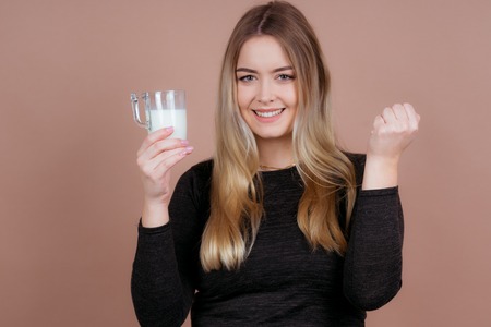 a girl likes to drink milk to stay healthy with a glass