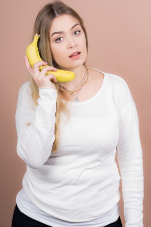 a girl plays with a banana and had funの写真素材