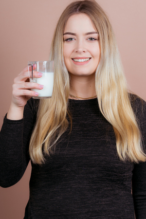 a girl likes to drink milk to stay healthy with a glassの写真素材