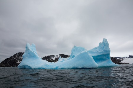 icecaps in the Antarctica with iceberg in the ocean swimming around and melting in the seaの写真素材