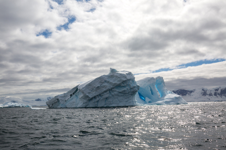 icecaps in the Antarctica with iceberg in the ocean swimming around and melting in the seaの写真素材