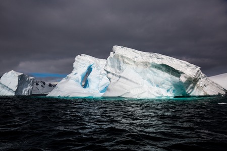 icecaps in the Antarctica with iceberg in the ocean swimming around and melting in the seaの写真素材