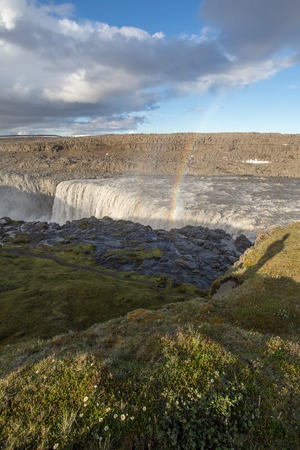 a waterfall in iceland between the mountains from the river springの写真素材