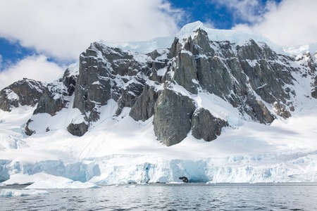 icecaps in the Antarctica with iceberg in the ocean swimming around and melting in the seaの写真素材