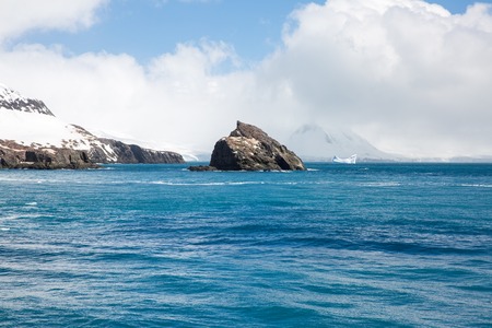 icecaps in the Antarctica with iceberg in the ocean swimming around and melting in the seaの写真素材