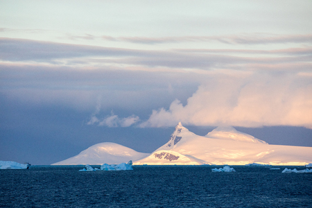 icecaps in the Antarctica with iceberg in the ocean swimming around and melting in the seaの写真素材