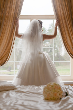 Bride looking through the windowの写真素材