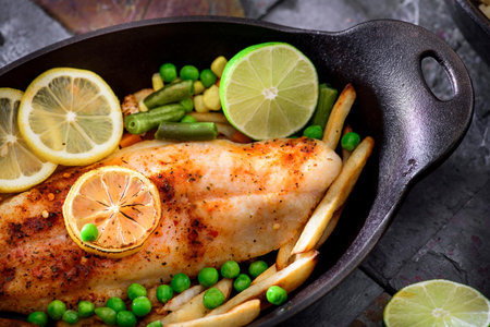 Flavorful Delight: Cajun Style Baked Fish Fillet with Fries and Lemon in Exquisite 4K Close-Up