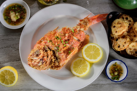 Deliciously Crispy: Top Close-Up of Deep Fried Red Snapper Fish lemon on a plate in 4Kの写真素材
