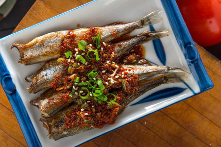 Savory Grilled Shishamo Fish Close-Up with Soy Sauce on Plate in 4K Resolutionの写真素材