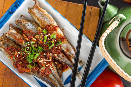 Savory Grilled Shishamo Fish Close-Up with Soy Sauce on Plate in 4K Resolutionの写真素材