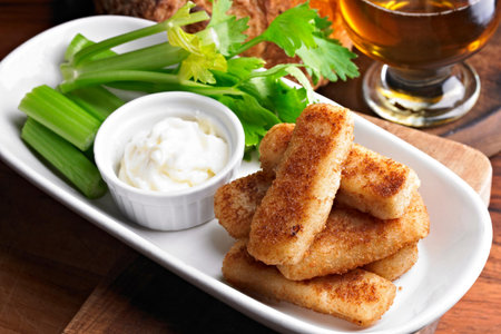 Close-Up of Crispy Fried Fish Sticks with Celery on Plate in 4K Resolutionの写真素材