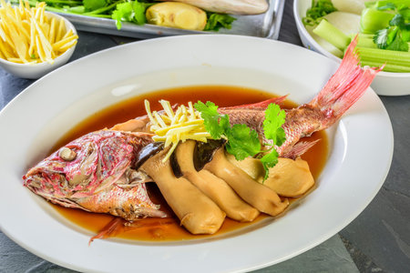 Flavors of the Sea: Top Close-Up of Whole Red Snapper Fish Cooked in Ginger Soy Sauce on Plate in 4Kの写真素材