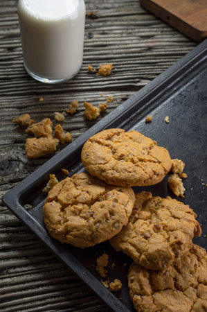 Homemade oatmeal cookies with a glass of milk on wooden backgroundの写真素材