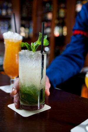 cocktail with ice and mint on a wooden table in the barの写真素材