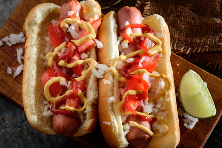 Hot dogs with ketchup, mustard and mayonnaise on wooden backgroundの写真素材