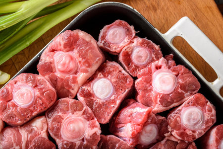 Raw pork with onions in a pan on a wooden cutting board.の写真素材