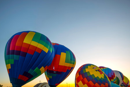 Colorful hot air balloons flying in the blue sky at sunrise.の写真素材