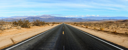 Panoramic view of an empty highway through the Mojave Desertの写真素材