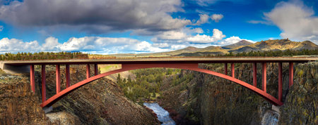 Panoramic view of a red bridge over a river in Iceland.の写真素材
