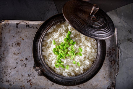 Rice with green beans in a pot on a dark background.の写真素材