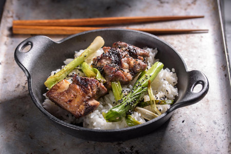 Pork belly with rice in a cast-iron frying pan.の写真素材