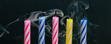 Birthday candles on a black background with smoke, close-upの写真素材