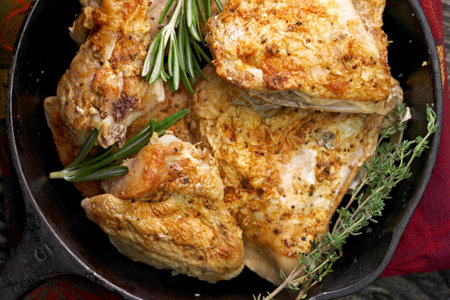 Roasted chicken with rosemary and thyme in a frying panの写真素材
