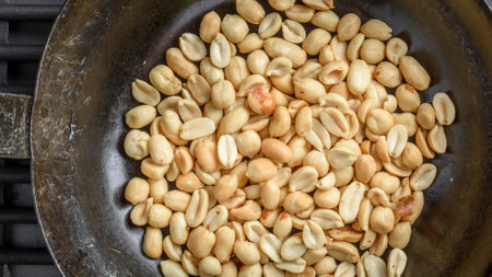 Roasted peanuts in a pan on the stove, close up.の写真素材