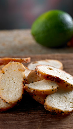 Crispy bread with sesame seeds and lime on wooden tableの写真素材