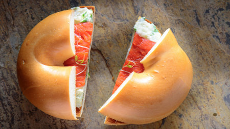 Delicious bagel with smoked salmon and cheese on wooden background.の写真素材