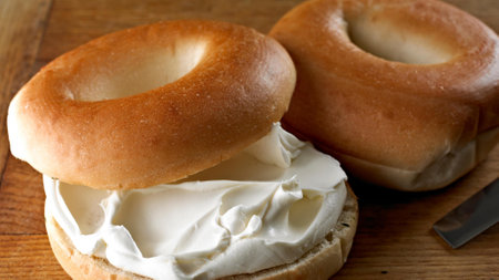 Bagel with cream cheese on a wooden table. Close up.の写真素材
