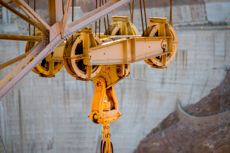 Close-up of a yellow crane hook on a construction site.