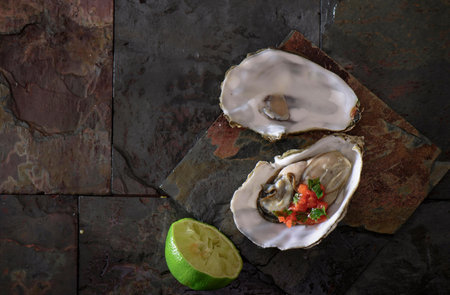 Oysters with lime on a stone background. Top view.