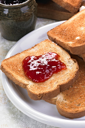 Toasted bread with strawberry jam for breakfast. Selective focus.の写真素材