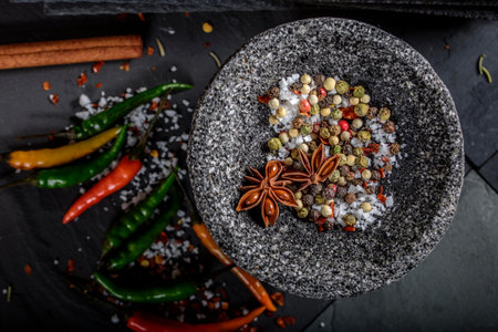 Mortar and pestle with spices on black stone background.の写真素材