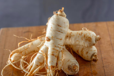 Fresh parsnip roots on a wooden cutting board close-upの写真素材