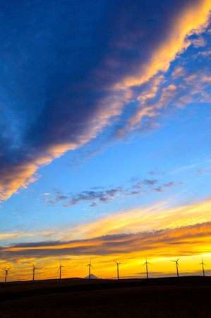Wind turbines at sunset in the prairie of Saskatchewan Canada with clouds in the skyの写真素材