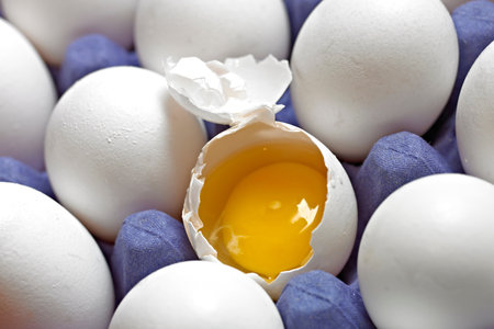 Eggs with a broken egg on a blue background. Close-up.