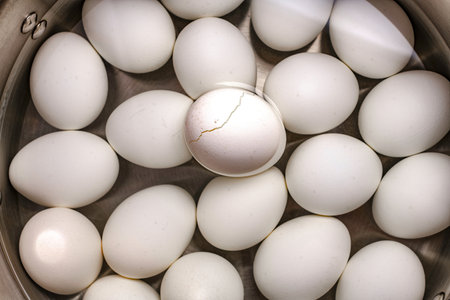 White chicken eggs in a metal bowl. Close-up shot.の写真素材